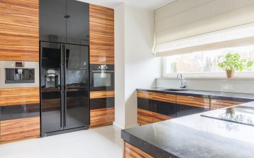 Kitchen with black marble worktop and fridge